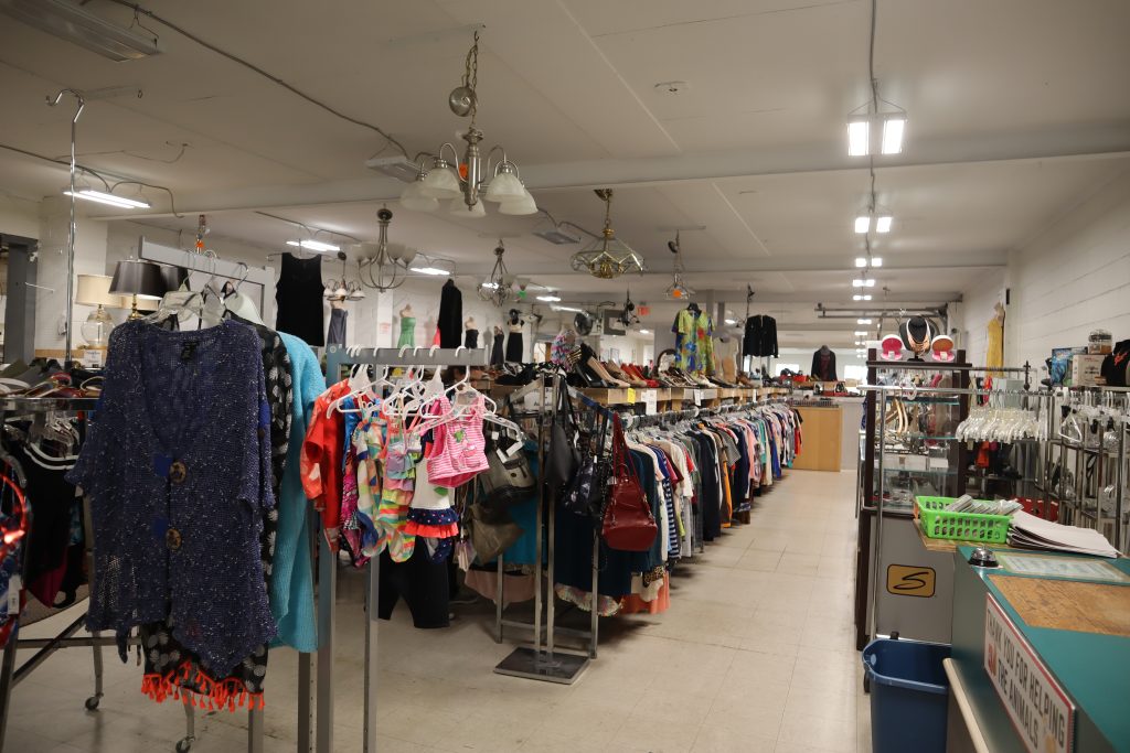 Stocked clothing racks at a thrift store.