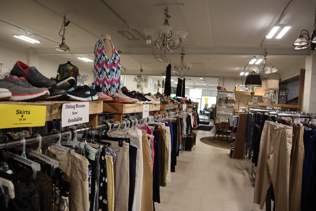 Stocked clothing racks at a thrift store.